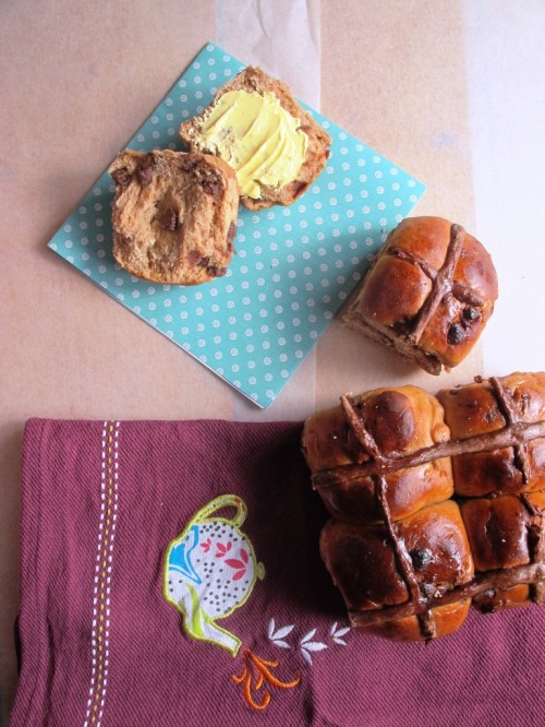 Chocolate chip hot cross buns with one ripped in half